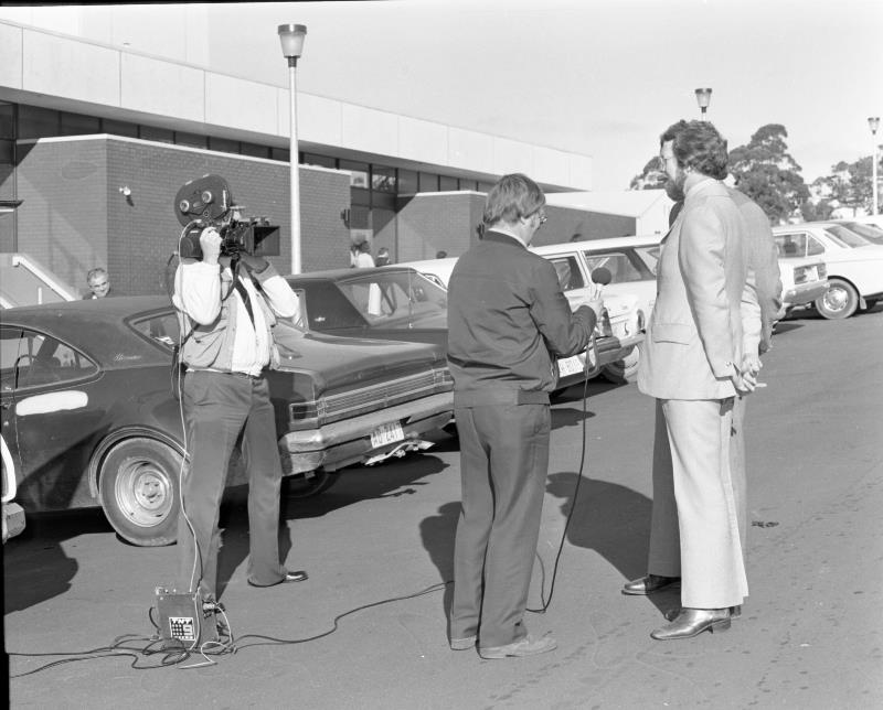 News reporter interviewing with camera man in 1976 black and white